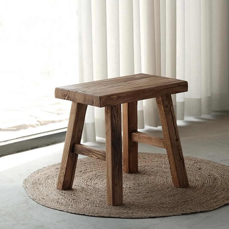 Long wooden bench with a weathered natural finish and splayed legs.