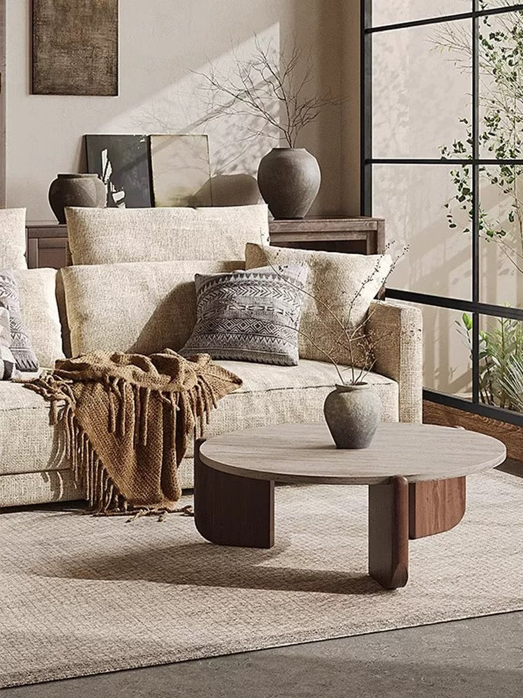 Detail shot of a round coffee table styled with a ceramic vase and minimalist decor.