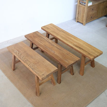 Three different sizes of rustic reclaimed wood benches on a jute ru