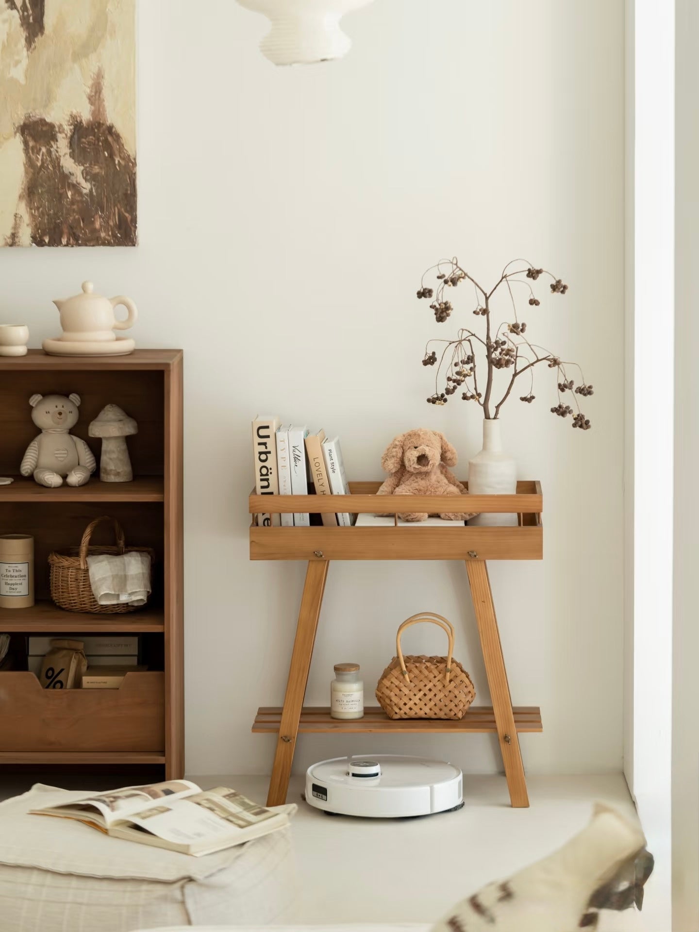 Mid-century modern wooden plant stand used as a nursery bookshelf with a plush toy.