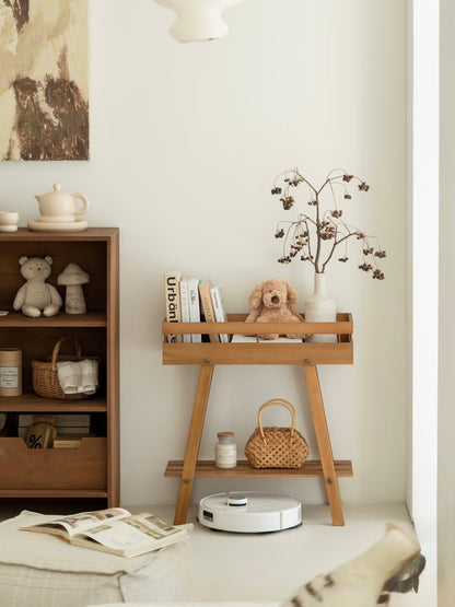 Mid-century modern wooden plant stand used as a nursery bookshelf with a plush toy.